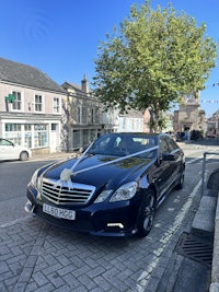 a black car parked on a cobblestone street